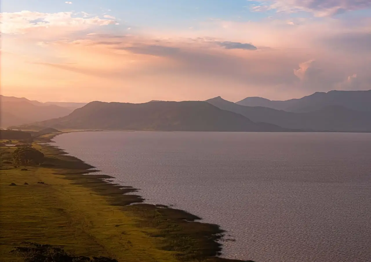 Ilustração da lagoa ao pôr do sol, em Maquiné, com os morros ao fundo